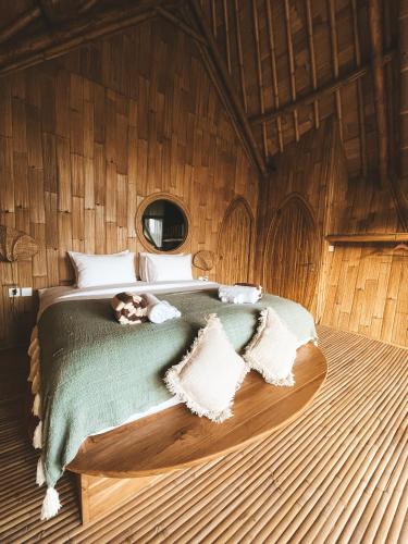 a bedroom with a bed in a wooden room at Kalma Bamboo Eco Lodge in Kuta Lombok