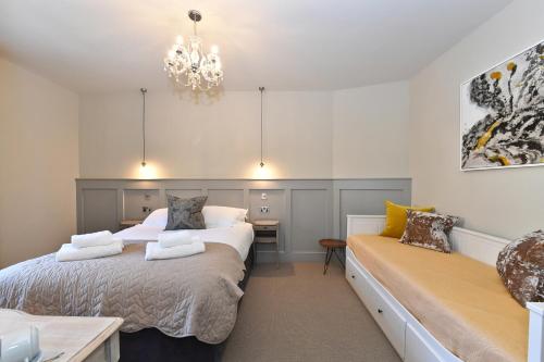 a bedroom with two beds and a chandelier at Lansdowne Strand in Calne