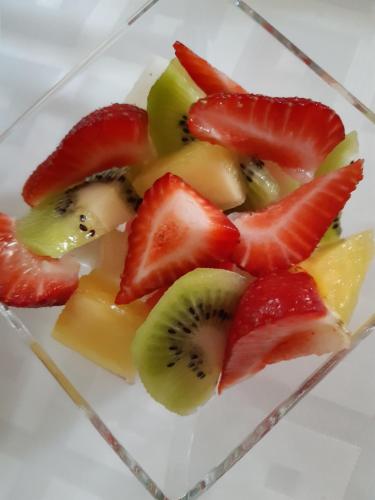 a plate with strawberries and kiwis and other fruit at Costa Trasmiera in Langre