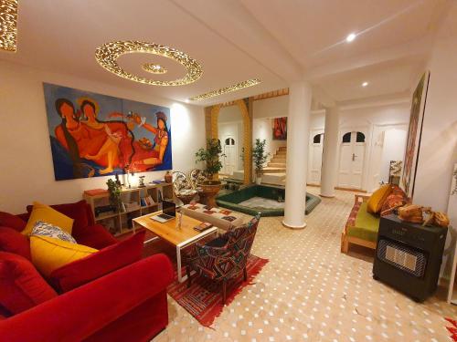 a living room with a red couch and a table at Art riad mazighen in El Jadida