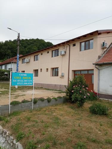 a sign in front of a building with a house at Casa Adelin in Eşelniţa