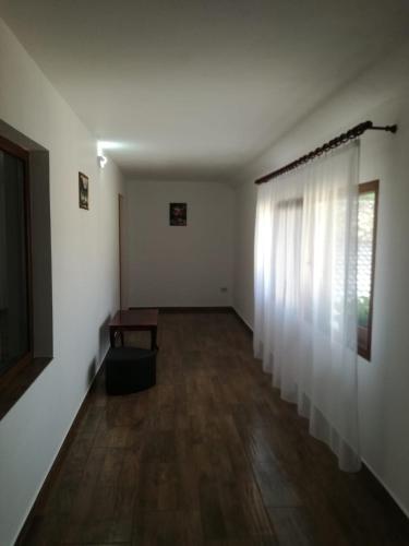 an empty room with white walls and a wooden floor at Casa Adelin in Eşelniţa