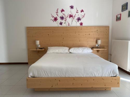 a bedroom with a wooden bed with flowers on the wall at B&B Stari Mlin - Vecchio Mulino in San Giorgio