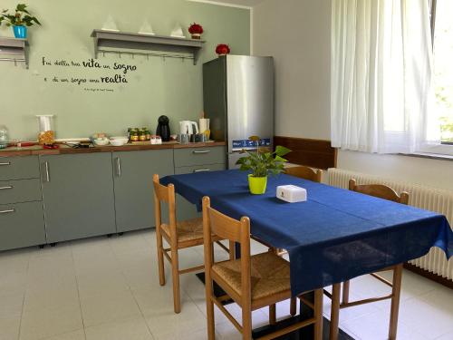 a kitchen with a blue table with chairs and a refrigerator at B&B Stari Mlin - Vecchio Mulino in San Giorgio
