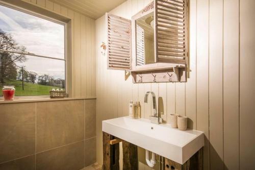 a bathroom with a white sink and a window at Sunbank Yurt in Llangollen
