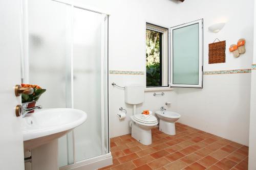 a bathroom with a toilet and a sink and a shower at Villa Rosa Dei Venti - Scopello-Villas in Scopello