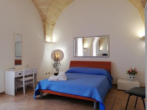a bedroom with a bed and a sink and a mirror at Dimora Cinzia in Uggiano la Chiesa