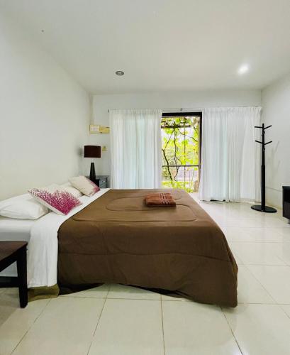 a bedroom with a large bed with a large window at Wassana Sitdharma Guesthouse in Ban Na Pho