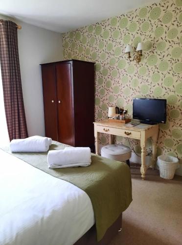a bedroom with a bed and a desk with a computer at Lansdowne Strand in Calne