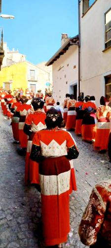 a group of people dressed in orange and red at B&B Santu Giuvanni "Un tuffo nel passato Fonnese" in Fonni