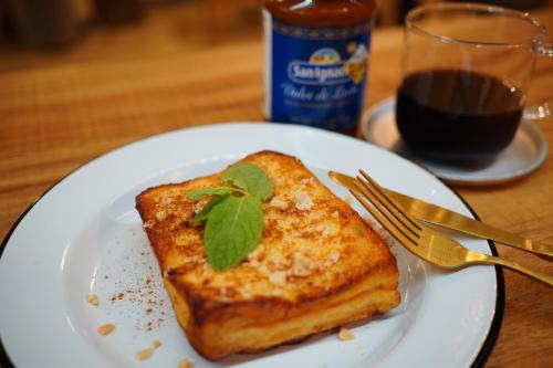 a white plate with a piece of toast with a green leaf on it at La Union in Fukushima