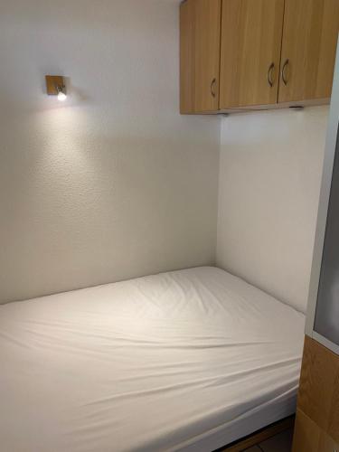 Cette petite chambre comprend un lit avec des draps blancs. dans l'établissement Appt briancon 4 pers au pied des remontés mécaniques le relais de la guisane, à Briançon