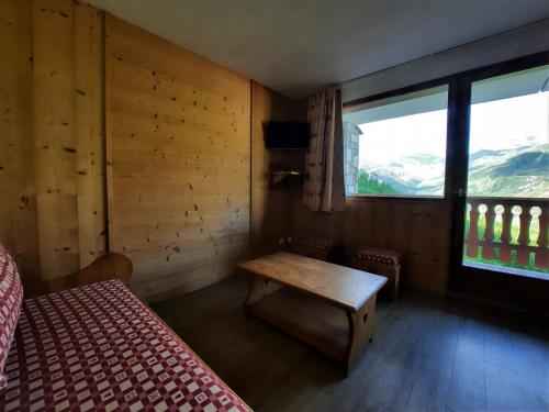 een kamer met een bed, een tafel en een raam bij Appartement Les Menuires, 3 pièces, 6 personnes - FR-1-452-16 in Les Menuires