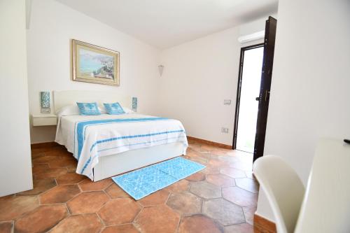 a bedroom with a bed with blue pillows on it at Tenute Efis in Galtellì