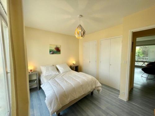 une chambre avec un lit et un lustre dans l'établissement Quiberon - Appartement T2 - 50m² - Plein centre, proche plage, parking privé, loggia sud - FR-1-478-218, à Quiberon