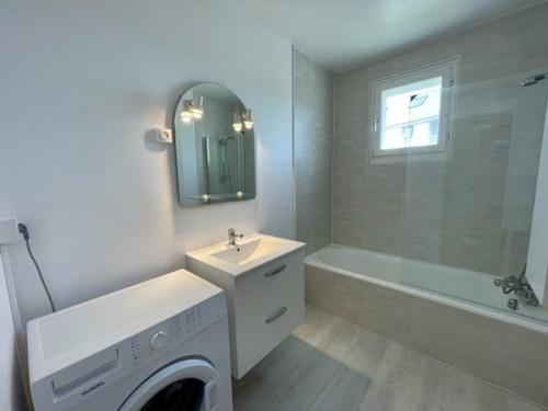 La salle de bains blanche est pourvue d'un lavabo et d'un lave-linge. dans l'établissement Quiberon - Appartement T2 - 50m² - Plein centre, proche plage, parking privé, loggia sud - FR-1-478-218, à Quiberon