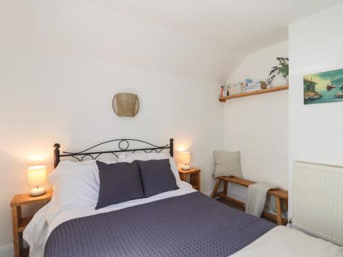 a bedroom with a bed and two lamps and a chair at Quayside Cottage in Teignmouth