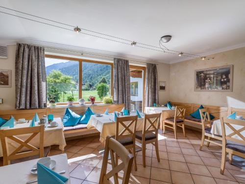 a restaurant with tables and chairs and a large window at Appartements Fortuna in Pertisau