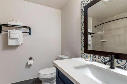 a white bathroom with a sink and a mirror at Comfort Inn Carmel By the Sea in Carmel