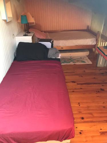 a bedroom with two bunk beds with a red blanket at Les balcons de la Medtirrannée front de mer in Narbonne-Plage