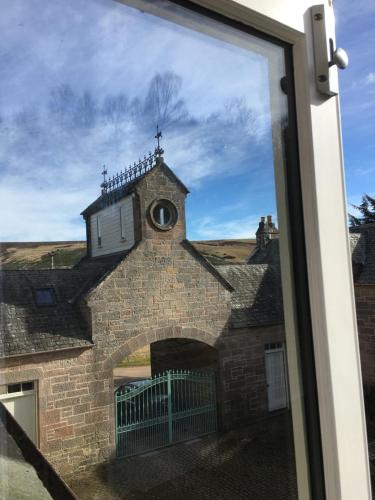 a building with a clock on the top of it at Brylach Steading in Aberlour