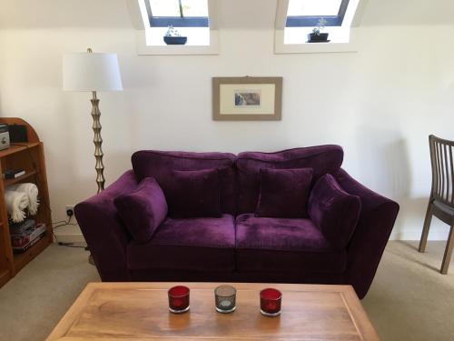 a purple couch in a living room with a table at Brylach Steading in Aberlour