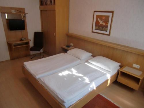 a hotel room with a bed and a television at Pension Daniela Steiner in Podersdorf am See