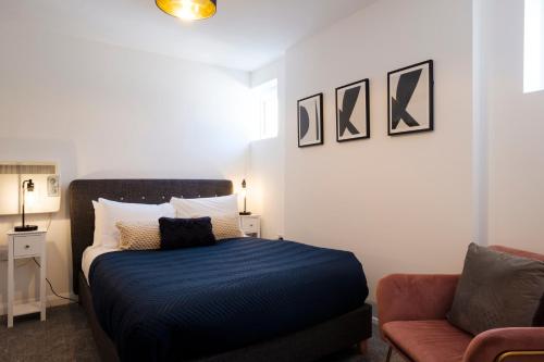 um pequeno quarto com uma cama e um sofá em Corinium Lodge - town centre apartment em Cirencester