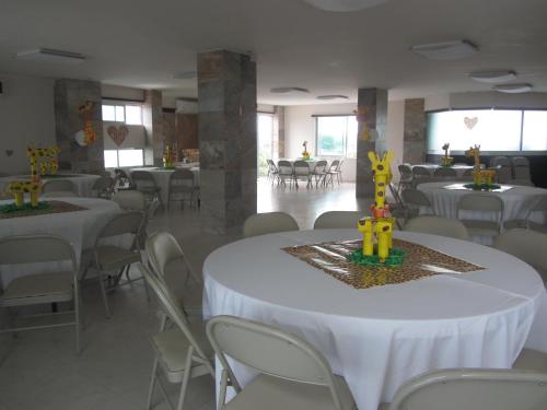 a banquet hall with white tables and white chairs at Hotel & Lounge Las Islas in San Juan Bautista Tuxtepec