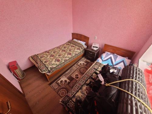 ein kleines Schlafzimmer mit 2 Betten und einem Tisch in der Unterkunft Guest House Pamir Nomad in Kara-Kavak