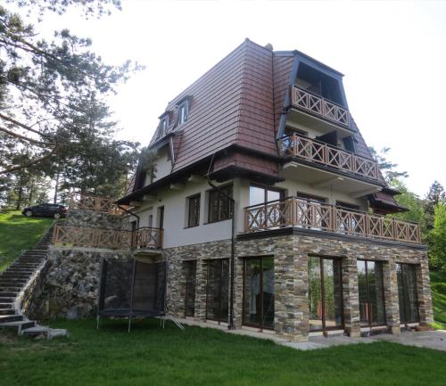 a large house with a balcony on top of it at KATUN Apartmani & SPA in Divčibare