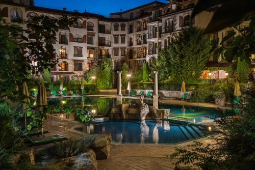 a hotel with a pool in front of a building at Esteban VIP Residence Club in Nesebar