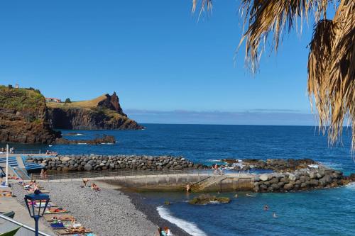 a group of people on a beach near the ocean at Suites Pinto Coelho in Caniço