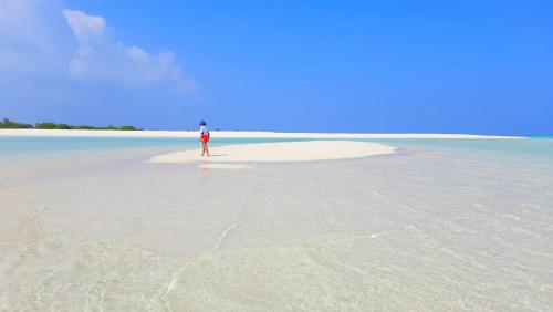 a person standing on a small island in the ocean at Mystic Maldives Mathiveri Retreat in Mathiveri