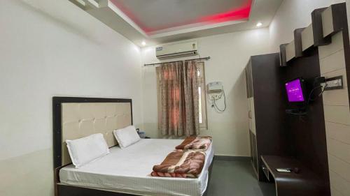 a small room with a bed and a tv at Hotel Prabhat Palace in Kota