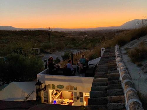 un groupe de personnes assises au coucher du soleil au sommet d'un bâtiment dans l'établissement Cuevas Andalucia, à Baza