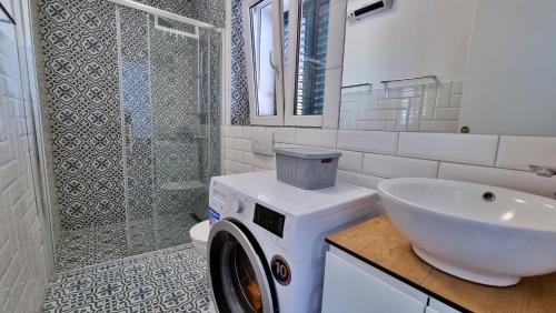 y baño con lavadora y lavamanos. en Apartment Adagio en Omiš
