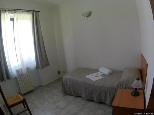 a small bedroom with a bed and a window at Terrae Eremis: Ristorante, Bar, B&B in Roccamorice