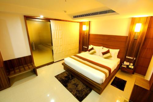 a bedroom with a bed and a shower in it at Hotel Hillway Park in Kollam