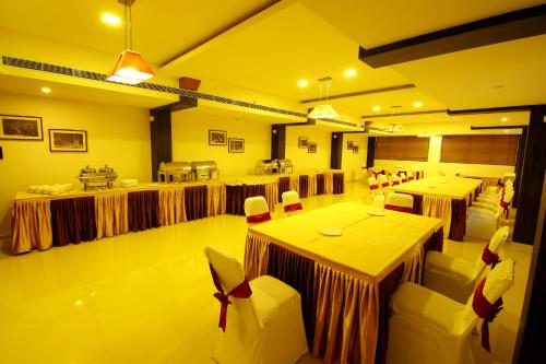 a large room with tables and chairs in it at Hotel Hillway Park in Kollam