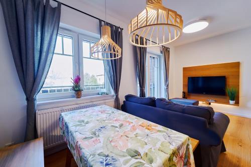 un soggiorno con divano blu e finestra di Marel-Apartments dwupoziomowy 24 Willa Leśna Polanica Zdrój a Polanica-Zdrój