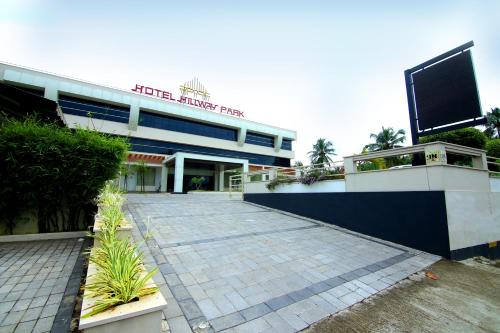a building with a parking lot in front of it at Hotel Hillway Park in Kollam