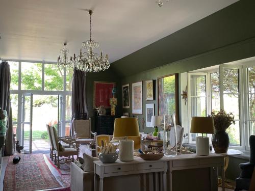 uma sala de estar com uma mesa e cadeiras e um lustre em Les Jardins Haute Couture em Huismes