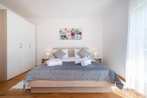 a white bedroom with a large bed with pillows at kuća za odmor ZARA in Stankovci