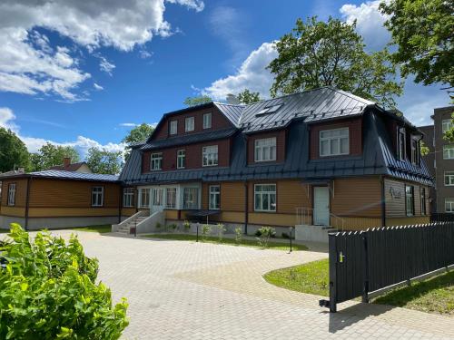 a large house with a black roof at Verona Apartments in Paide