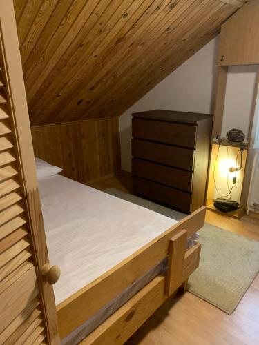 an attic bedroom with a bed and a dresser at Domek Sielanka Rybalnia in Szypliszki