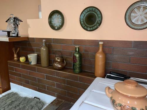 a bunch of vases and plates on a brick wall at Domek Sielanka Rybalnia in Szypliszki