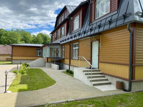 a wooden house with a staircase in front of it at Verona Apartments - Paide in Paide