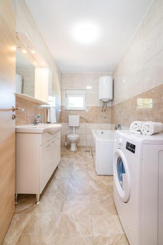 a bathroom with a washing machine and a sink at kuća za odmor ZARA in Stankovci