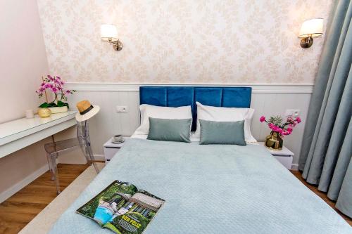 a bedroom with a bed with a blue head board at Apartament Sun Mare in Gdańsk